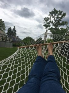 An image of a pair of legs stretched out on a hammock, as the viewer reclines.